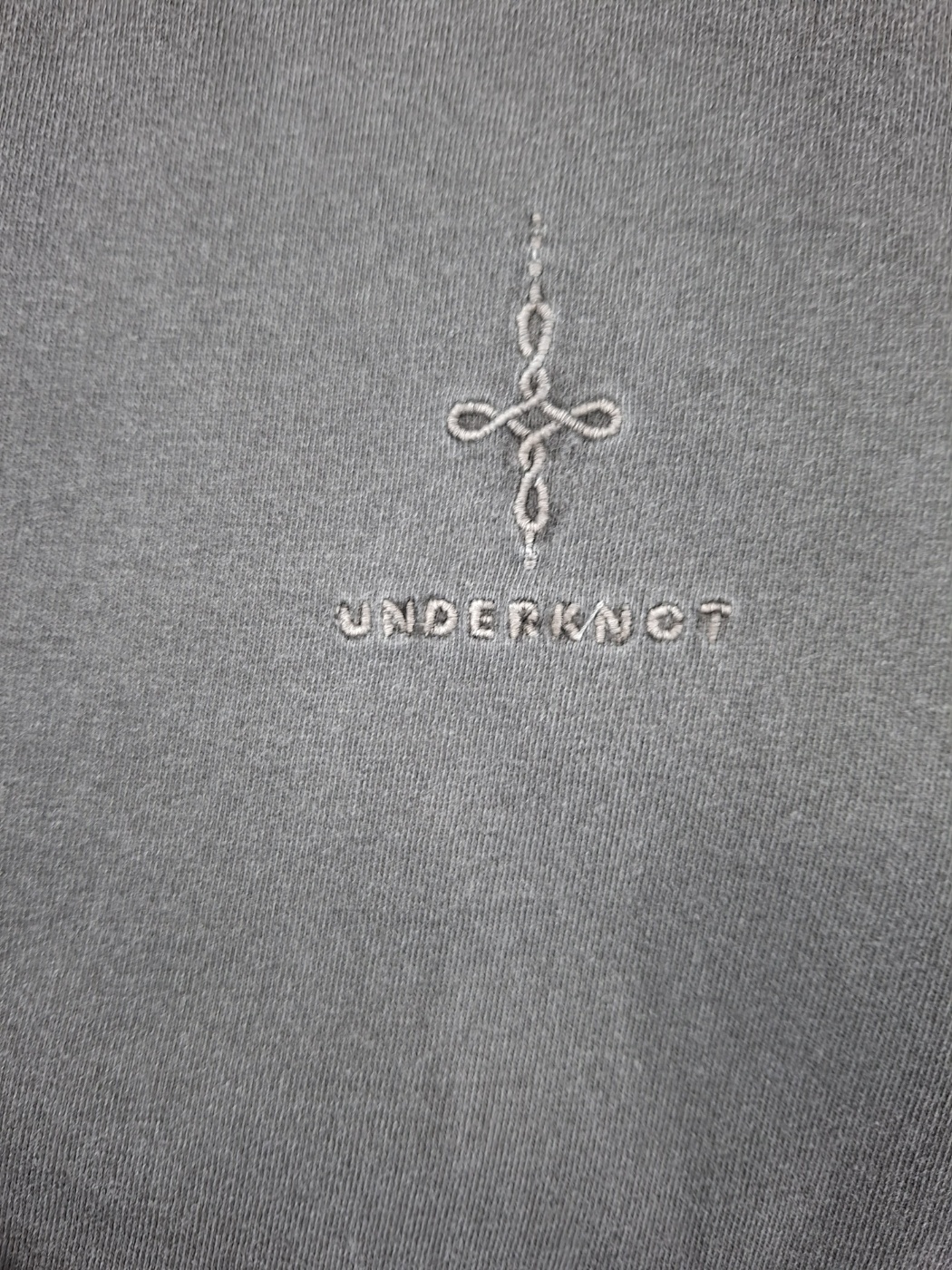 Wordmark + knot embroidery on an UNDERKNOT physical sample, received September 6